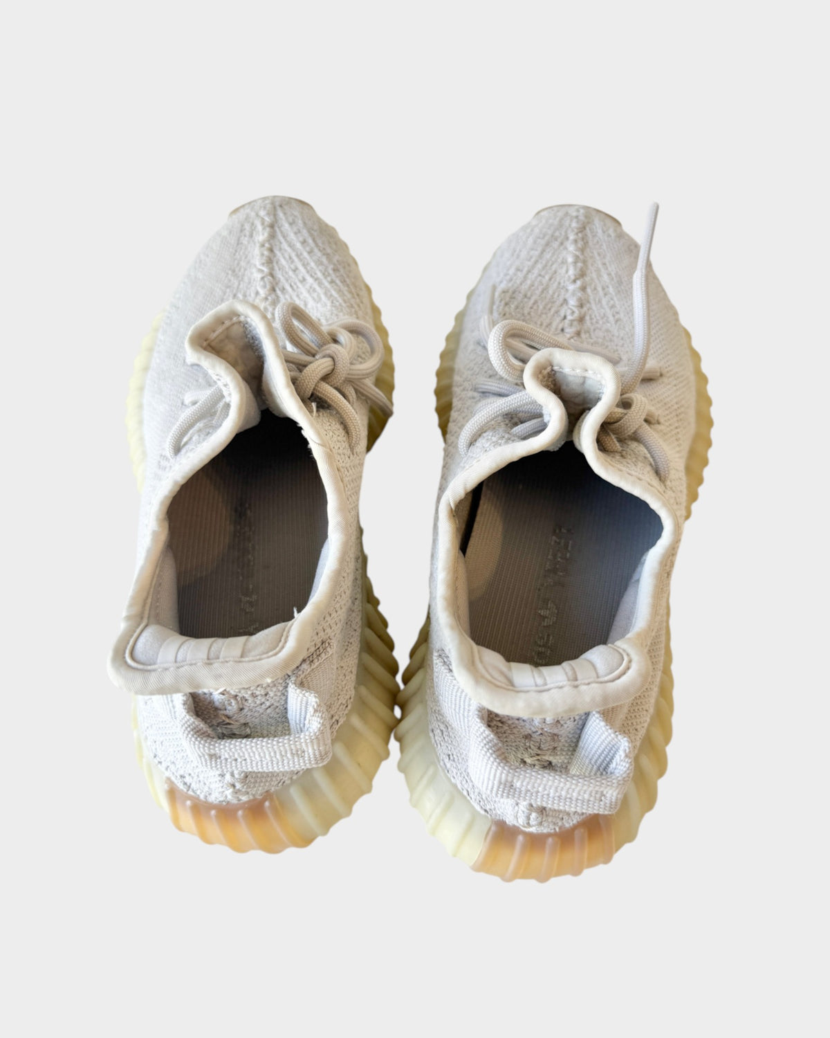 Lula and Mimi Adidas x Yeezy Boost 350 V2 Sesame sneakers in beige Primeknit with signature Boost soles, top view.