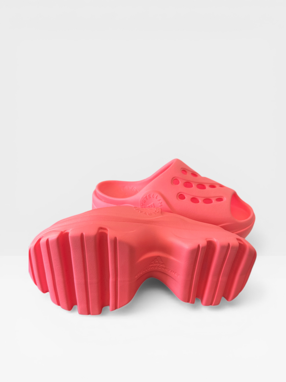 Adidas by Stella McCartney chunky clog sandals in neon coral, side view showing cleated sole