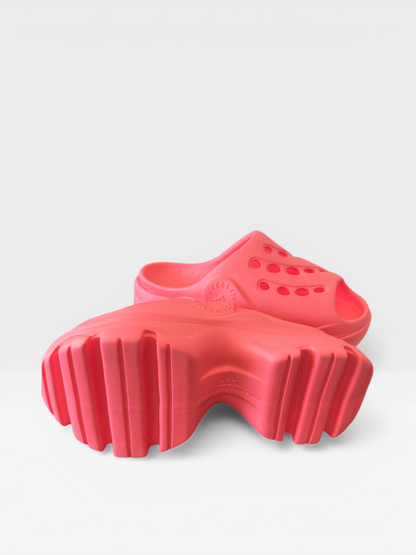 Adidas by Stella McCartney chunky clog sandals in neon coral, side view showing cleated sole