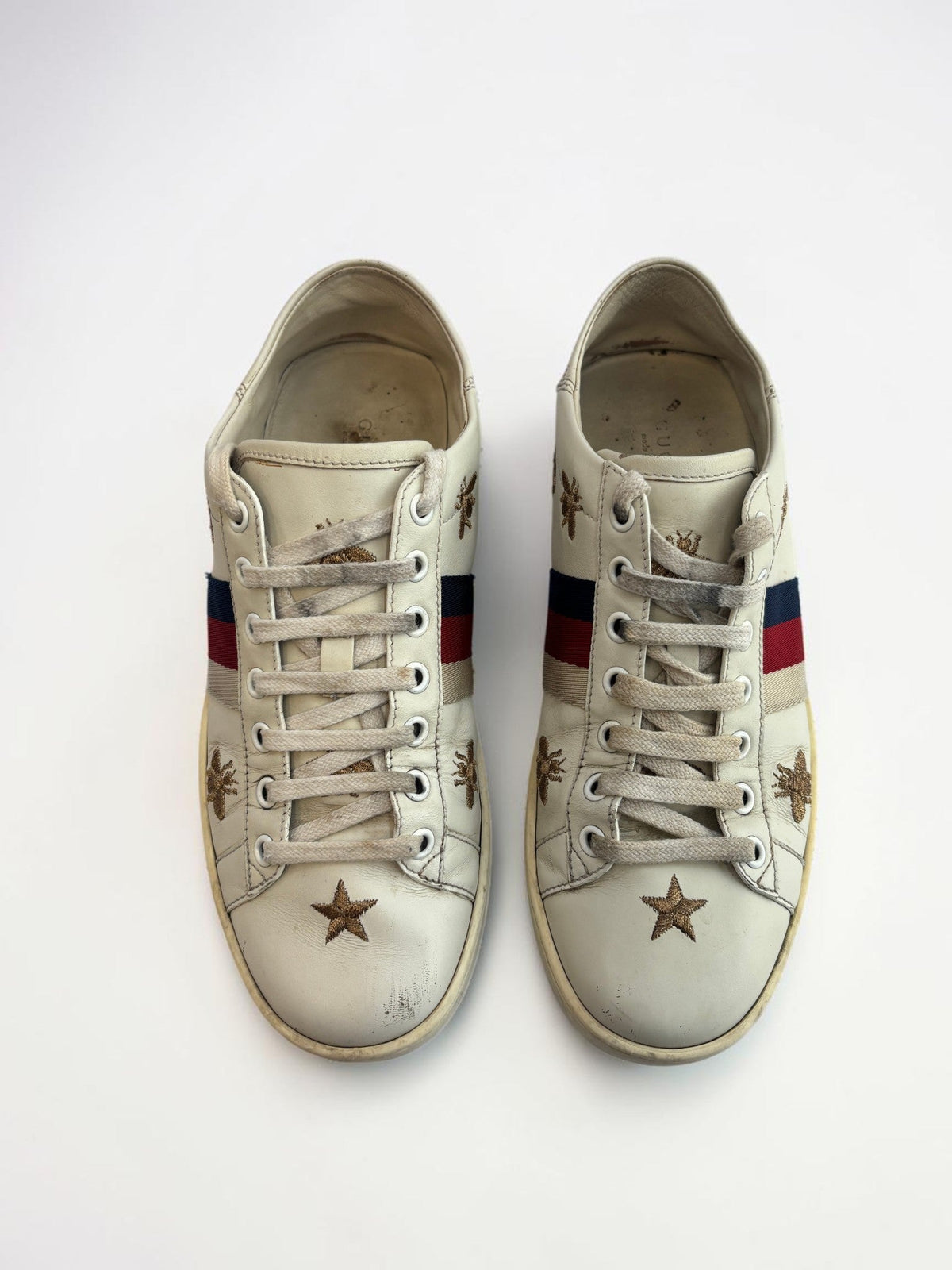 Gucci Ace Bee Star embroidered leather sneakers in white, side view showing bee and star embroidery