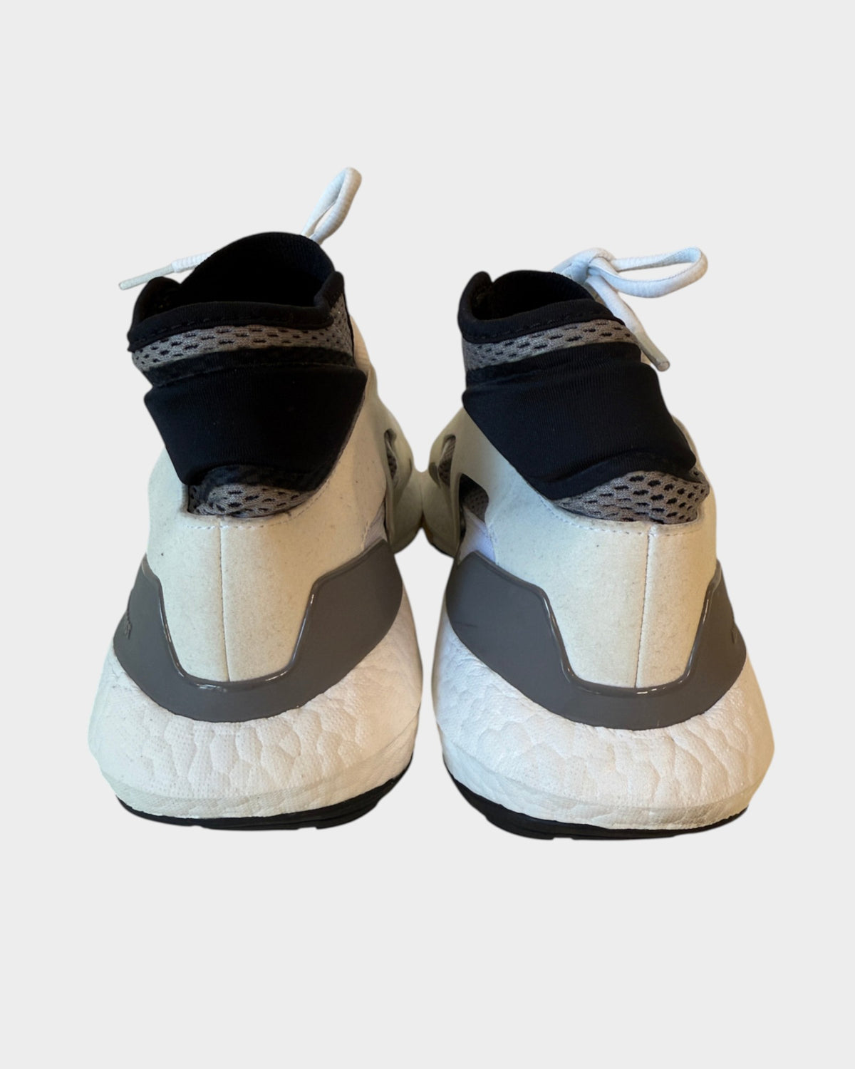 Lula and Mimi Adidas x Stella McCartney Ultraboost sneakers, rear view showing white Boost soles and black collars.