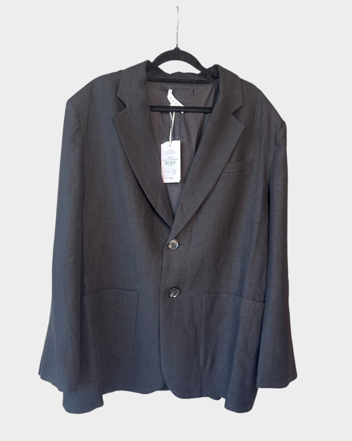 Lula and Mimi AERE oversized black linen blazer with original tags attached hanging on a black hanger