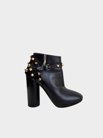 Lula and Mimi Balenciaga black leather ankle boots featuring gold-tone studs, a buckle strap, and a high block heel.