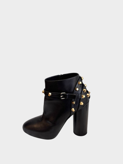 Lula and Mimi Balenciaga black leather ankle boots featuring gold-tone studs, a buckled strap, and a chunky block heel.