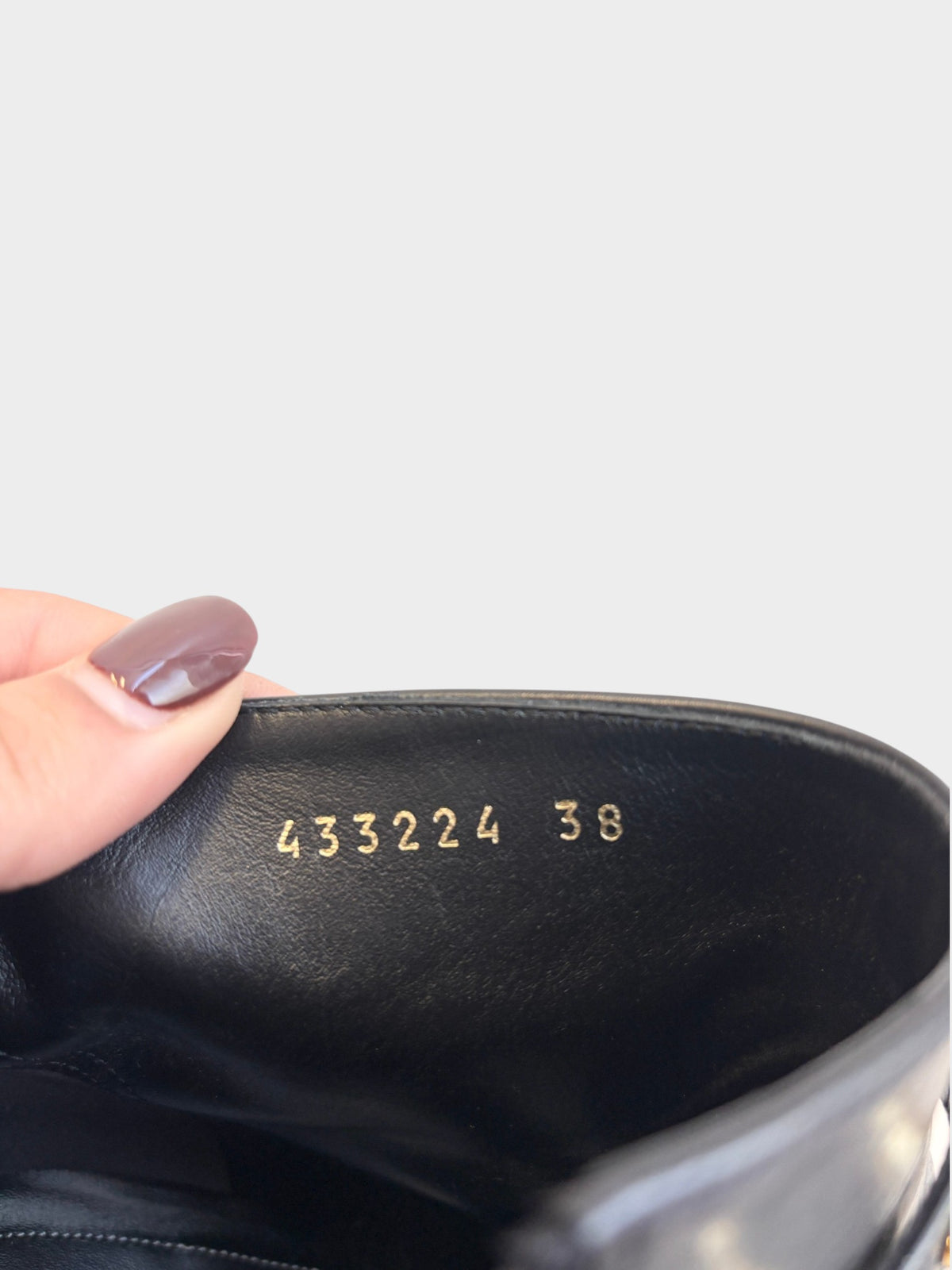 Interior of a black leather Balenciaga ankle boot showing the gold stamped serial number 433224 and size 38 at Lula and Mimi
