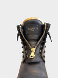 Lula and Mimi Balmain black leather army boots featuring gold hardware, front zipper, and metallic tongue detail.