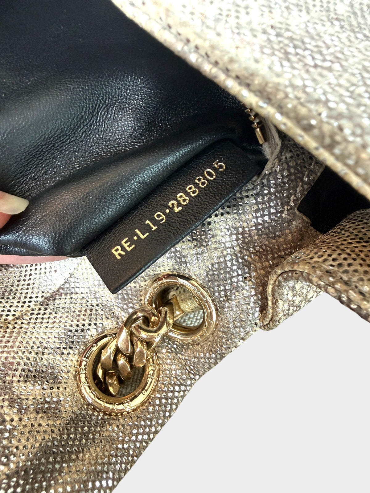 Lula and Mimi Bvlgari Serpenti Cabochon bag interior showing the gold embossed serial number tag and chain hardware