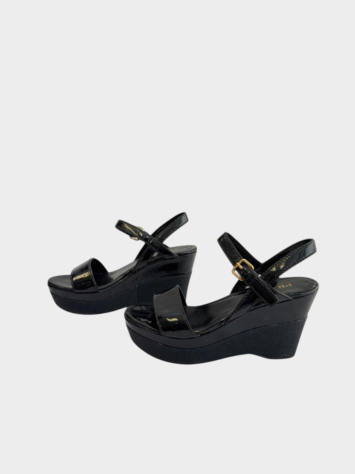 Lula and Mimi Prada Sport black patent leather platform wedge sandals with gold-tone ankle strap buckles.