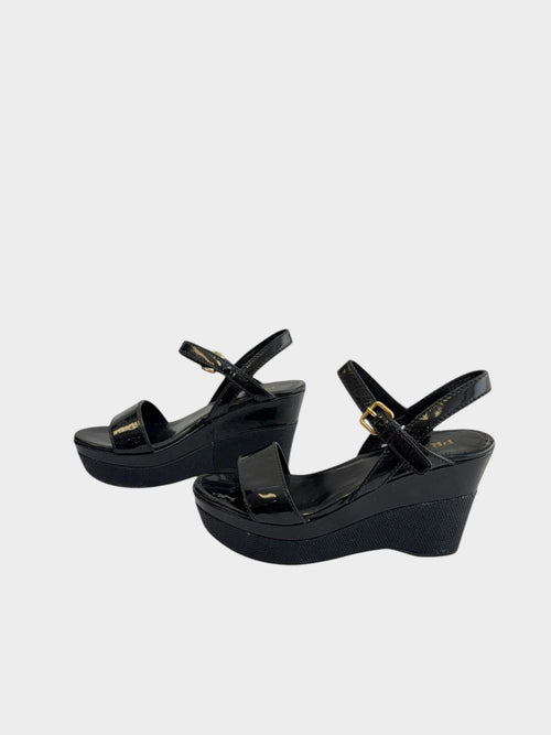 Lula and Mimi Prada Sport black patent leather platform wedge sandals with gold-tone ankle strap buckles.
