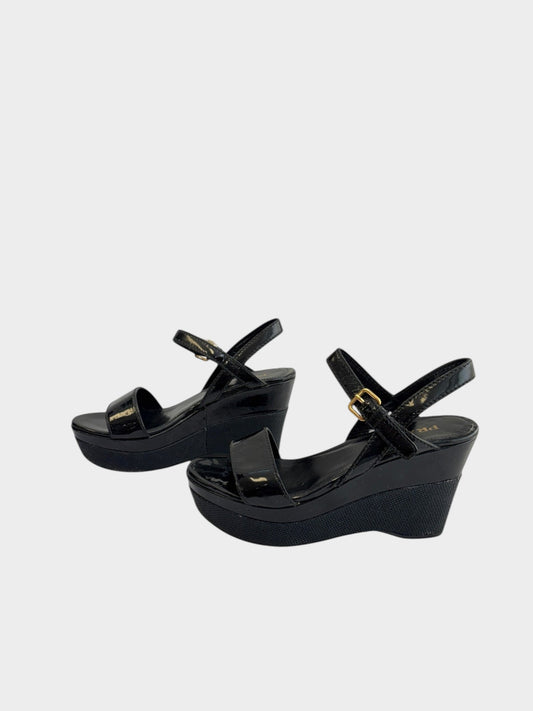 Lula and Mimi Prada Sport black patent leather platform wedge sandals with gold-tone ankle strap buckles.