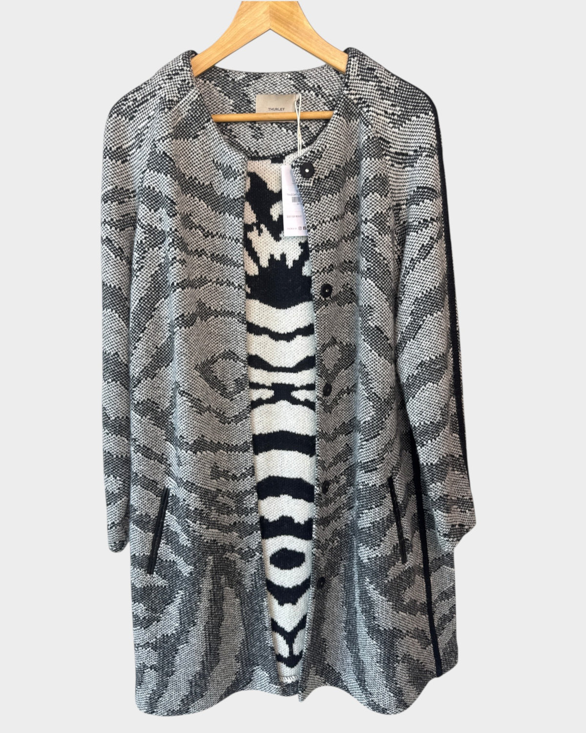 Lula and Mimi Thurley longline knit coat in a grey and black animal print with front buttons and side pockets.